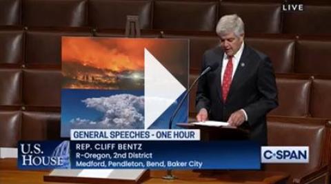 Congressman Bentz Speaking in House Chamber with photo displayed of fires and smoke filled sky